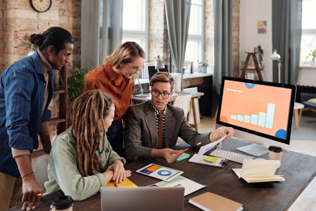 Equipo de agencia de marketing digital revisando estrategia y analítica en pantalla de computadora