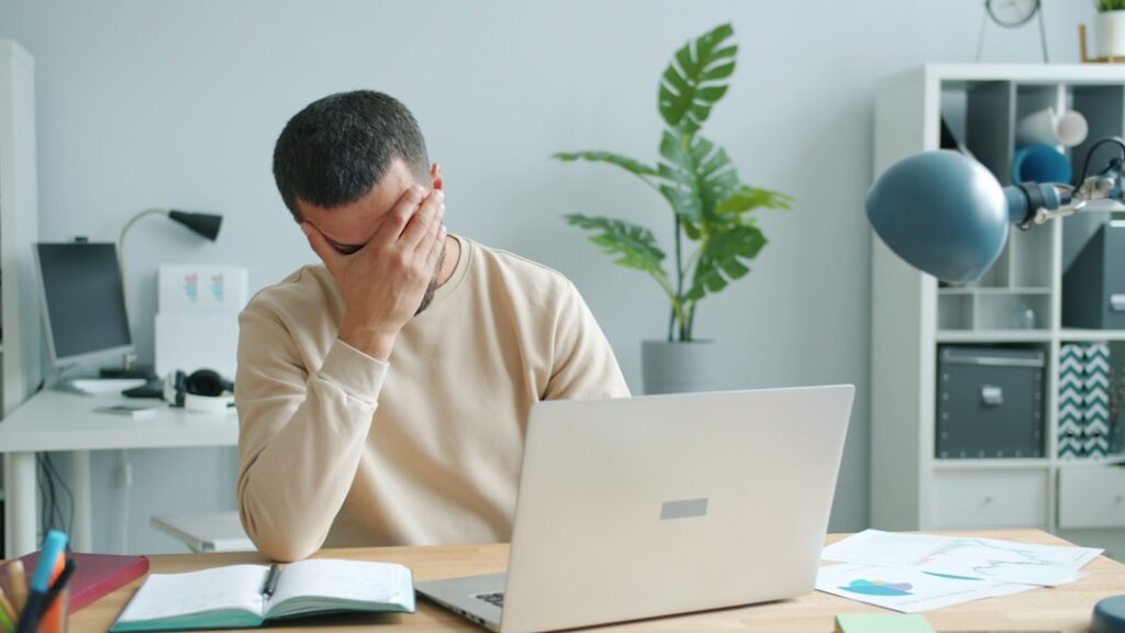 Dueño de PyME frustrado frente a su computadora revisando resultados de SEO que no cumplieron expectativas